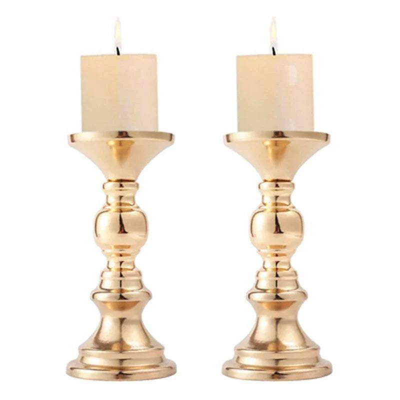 Pair of elegant golden candle holders with white candles for wedding and home decor