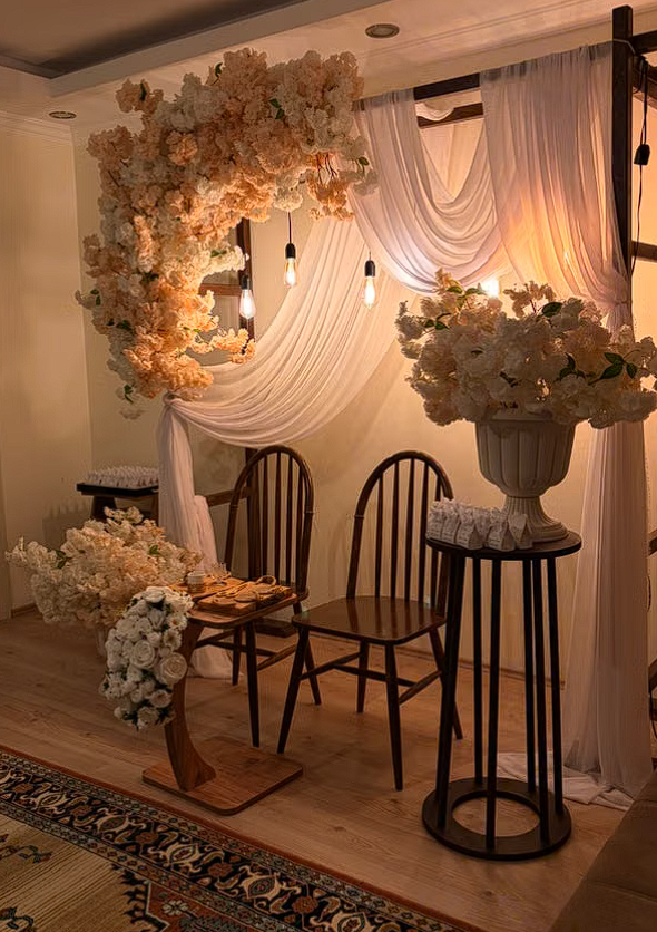 beautiful pink and white roses on an arch with chiffon drapery