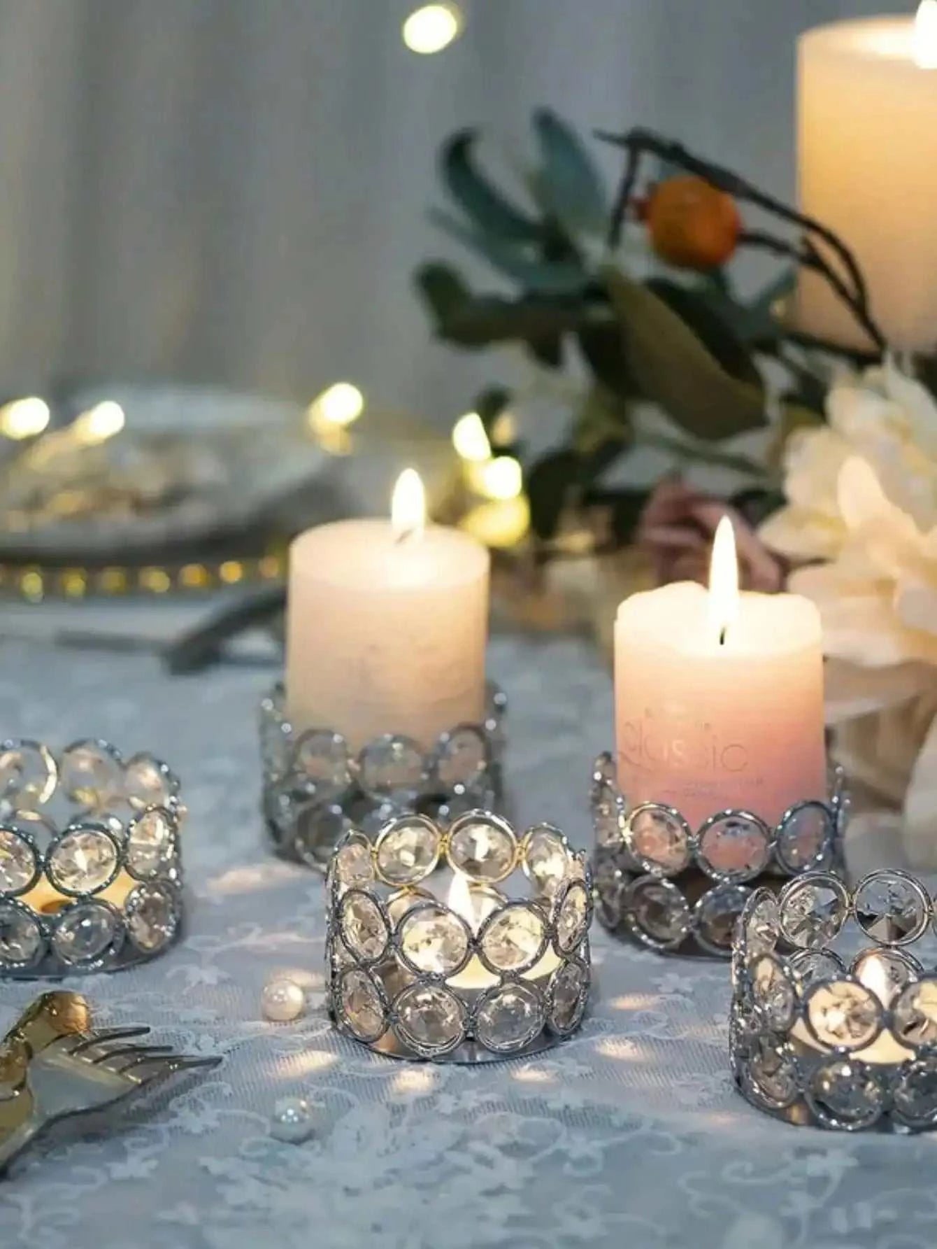 Silver gold crystal tea candle holders with lit candles on wedding table decoration