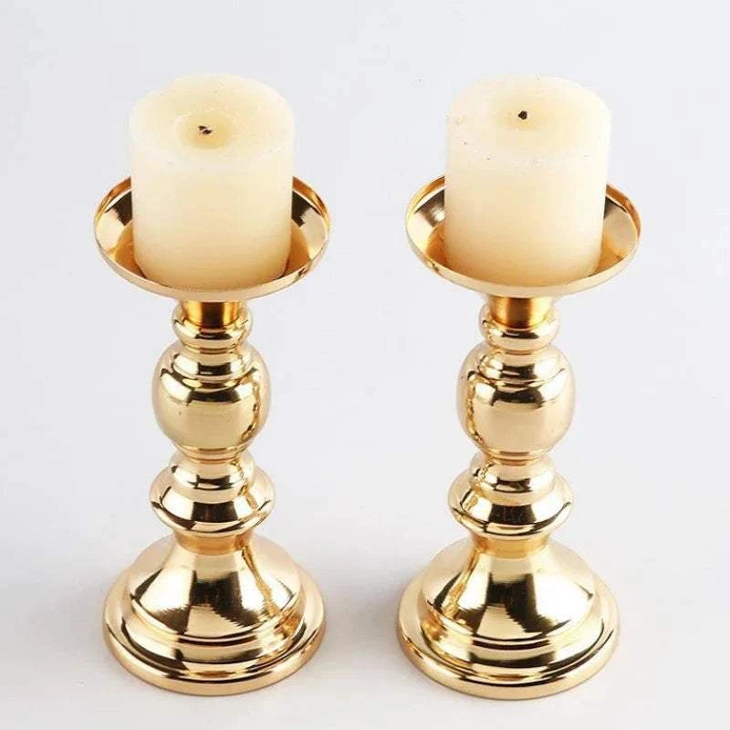 Pair of elegant golden candle holders with white pillar candles for wedding and home decor